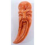 Chinese carved coral figure in the form of a beaded man's head, 4.5cm long.