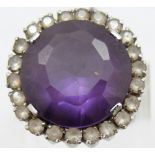 A white metal ring set with a synthetic purple sapphire surrounded by white sapphires, 11.5g, size