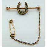 Victorian yellow metal brooch set with seed pearls in the form of a horseshoe