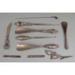 Five hallmarked silver handled button hooks and shoe horns, hallmarked silver novelty golf club