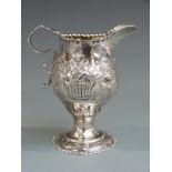 George II hallmarked silver jug with embossed decoration, London 1759 maker's mark rubbed, height