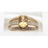 A 9ct gold ring set with an oval cut citrine and diamonds, 3.7g, size P