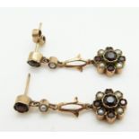 A pair of 9ct gold earrings set with garnets and seed pearls