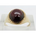 A 9ct gold ring set with a garnet cabochon, 3.4g, size N