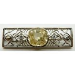 A 1920s Art Deco brooch set with a natural untreated cushion cut yellow Sri Lankan sapphire