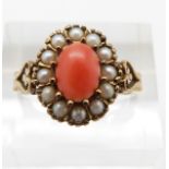 A yellow metal ring set with an oval coral cabochon surrounded by seed pearls, 3.3g, size P