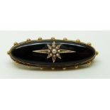 Victorian brooch set with onyx and seed pearls to the centre in a star setting