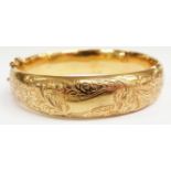 A 9ct gold bangle with engraved scrolling decoration, 14.5g (6.1 x 5.7cm)