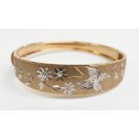 A 9ct gold bangle with foliate design, 9.69g, 5.7 x 5.3cm