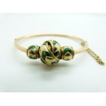 Yellow metal bangle with knotted section set with green and white enamel, 20.7g, 5.7 x 4.1cm