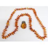 An amber necklace with angular pieces interspersed with cylindrical glass beads, 74g together with a