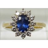 An 18ct gold ring set with an oval cut sapphire measuring approximately 1ct surrounded by