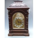 Victorian oak cased mantel/ boardroom clock ornately carved with masks and fruit, the silvered Roman
