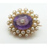 Edwardian brooch set with an, oval cut amethyst surrounded by seed pearls with a diamond to the