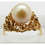 A 14k gold ring set with a pearl in a textured setting, 3.1g, size K