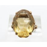 A 9ct gold ring set with an oval cut citrine in a scrolling setting, 5.9g, size M