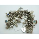 A silver charm bracelet with 42 charms including a Maori tiki, koala, platypus, lamb, cuckoo