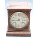 An oak cased two train mantel clock with silvered Roman dial, the two train movement striking on a