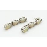 A pair of 14ct white gold earrings each set with three oval opal cabochons