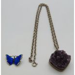 A silver necklace set with a section of amethyst by Bent K Denmark and a silver butterfly brooch set