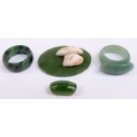 A nephrite jade plaque set with teeth and two jadeite rings