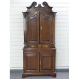 Antique oak double height cupboard, the top having arch top doors opening to reveal shaped
