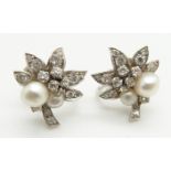 A pair of early 20thC white metal earrings set with two pearls and diamonds to each in the form of a