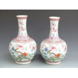 A pair of Chinese famille rose bulbous pedestal roulade vases with foliate, floral and bat