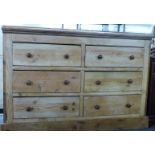A 19th/20thC pine chest of six straight drawers with turned knobs, raised on a straight plank