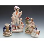Four 19thC Staffordshire figures including man with hunting dog and game, mounted rider and a