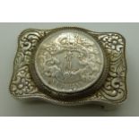 Chinese belt buckle in white metal floral and foliate design, coin to centre, pierced and signed