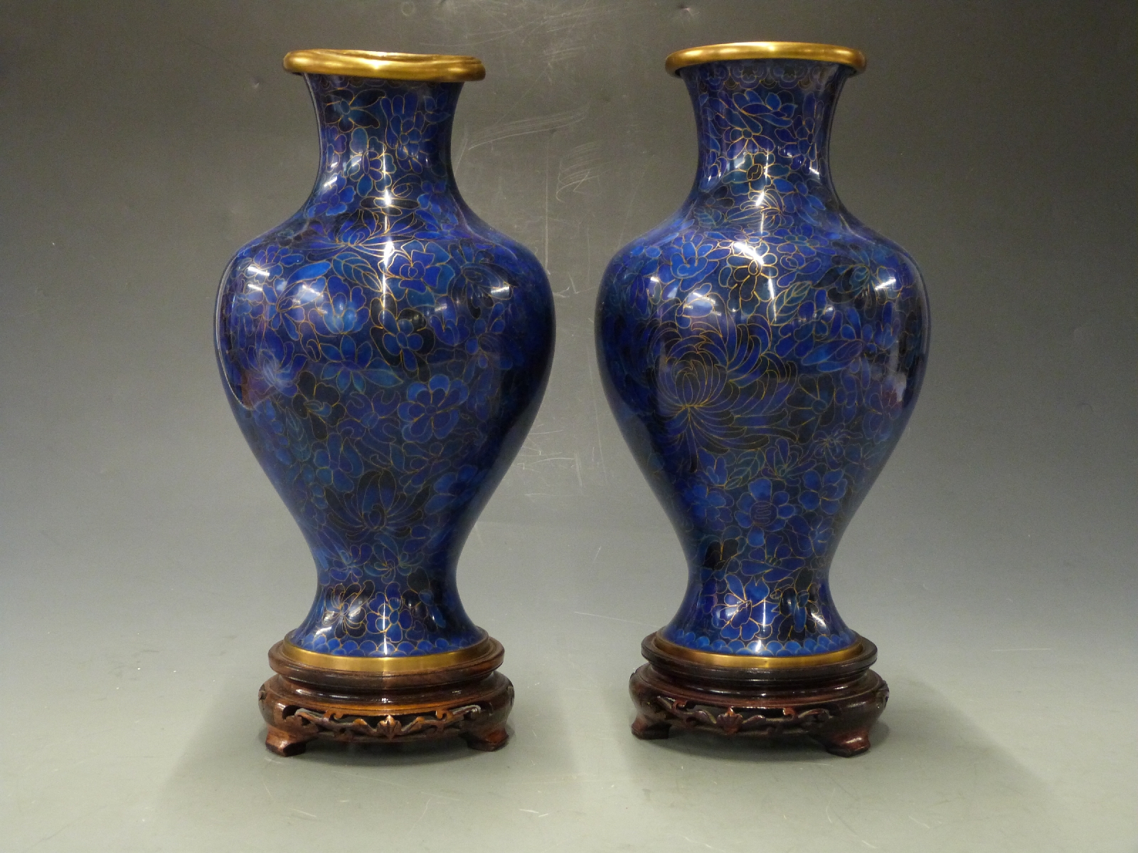 A pair of Japanese cloisonné vases on hardwood stands, 34cm tall