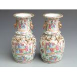 A pair of 19thC Chinese Canton famille rose vases of baluster form decorated with figural court