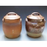 Two Winchcombe Pottery lidded twin handled crocks, one ribbed and the other with swirling