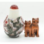 A Chinese glass overlaid scent bottle depicting a dragon and a boxwood netsuke depicting two cats,