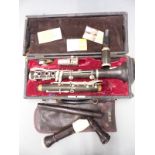 Pagot et Cie composite bodied clarinet stamped B, with spare reeds and some pre-decimal coins, in