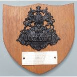 Cast iron fire mark insurance plaque with 'The Oxford' in raised script, mounted on oak shield