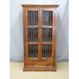 An Eastern hardwood bookcase with drawer under and decorative ironwork doors, W85 x D39 x H159cm