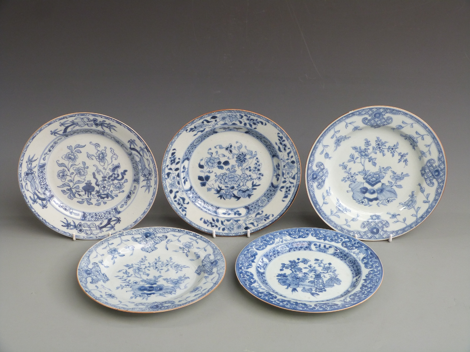 Five 19thC Chinese export plates decorated with vases of peonies, chrysanthemums, fruit and