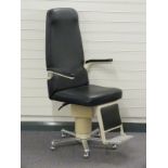 Optician's chair with folding arms and footrest and metal base raised on castors