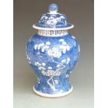 A 19thC Chinese covered pedestal ginger jar decorated with prunus blossom, four character underglaze
