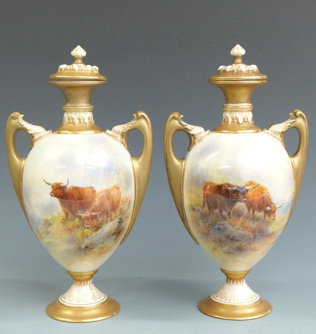 Royal Worcester pair of pedestal twin handled covered vases decorated with Highland cattle in
