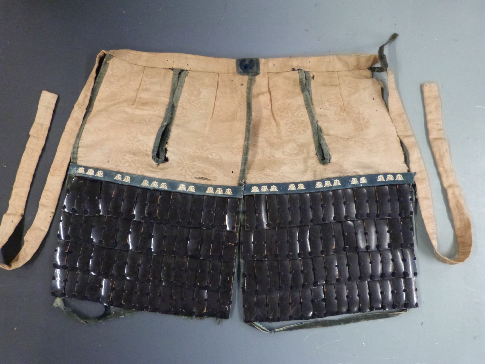 Japanese Edo period haidate yoroi (thigh armour) of lacquered leather construction with silk lining,