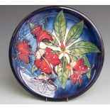 Moorcroft signed charger decorated with a variation of Hibiscus pattern dated 1999, boxed,