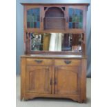 Arts and Crafts oak dresser, the top having two cupboards with leaded glass doors over a bevelled