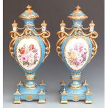 Pair of large porcelain pedestal twin handled covered vases with decorated cartouches of flowers and