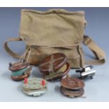 A collection of five vintage wooden and Bakelite fishing reels with a canvas bag