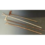 Four walking / shooting sticks with shaped tops and handles