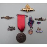 A collection of military badges and brooches to include silver sweetheart brooch for West