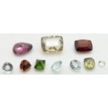 A collection of loose stones including three round cut aquamarines, feldspar, garnet, etc